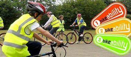 photo of a person wearing a hi-vis waistcoat and bike helmet, on a bike during a training session.