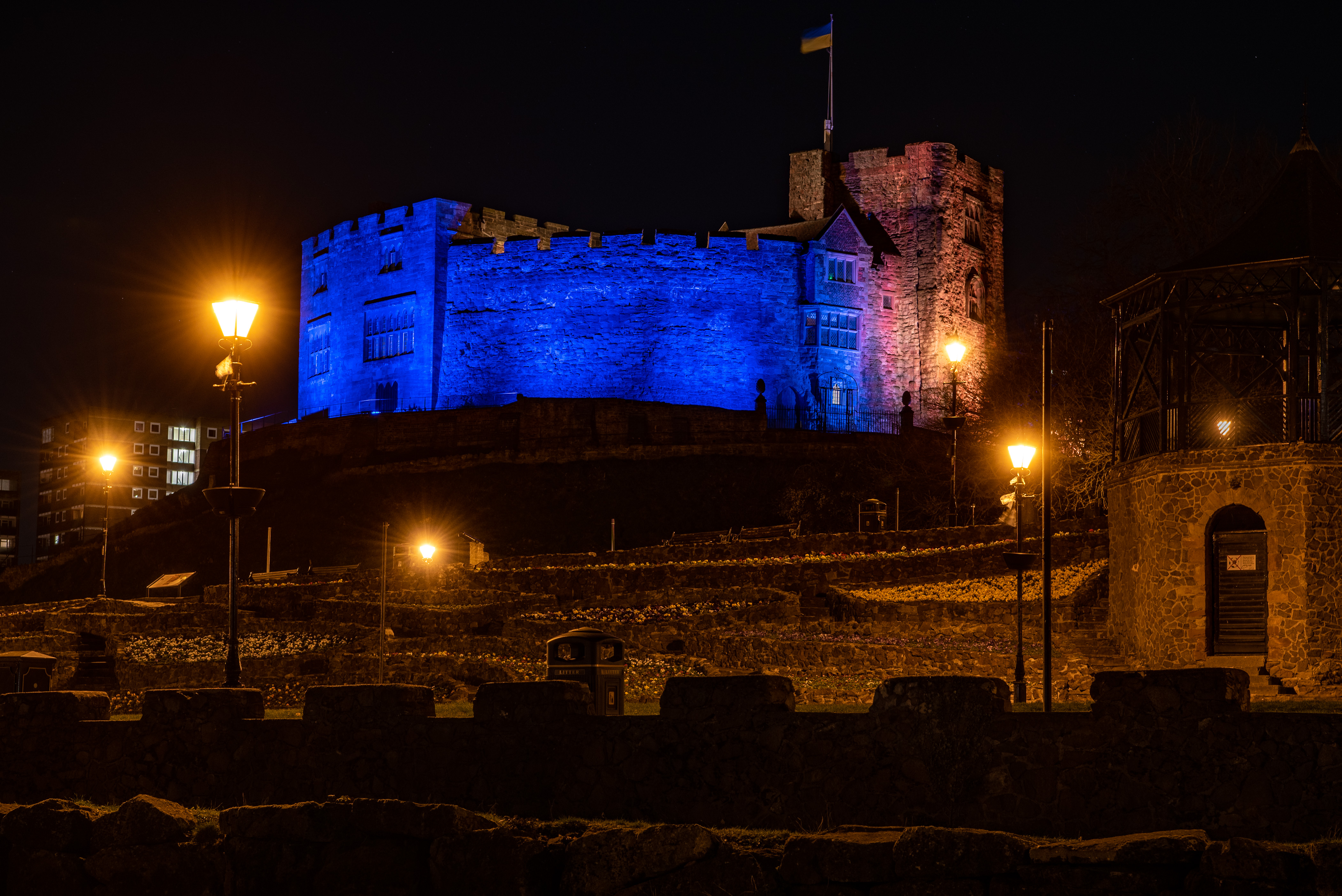 Image of Tamworth Castle at night, lit-up blue and yellow