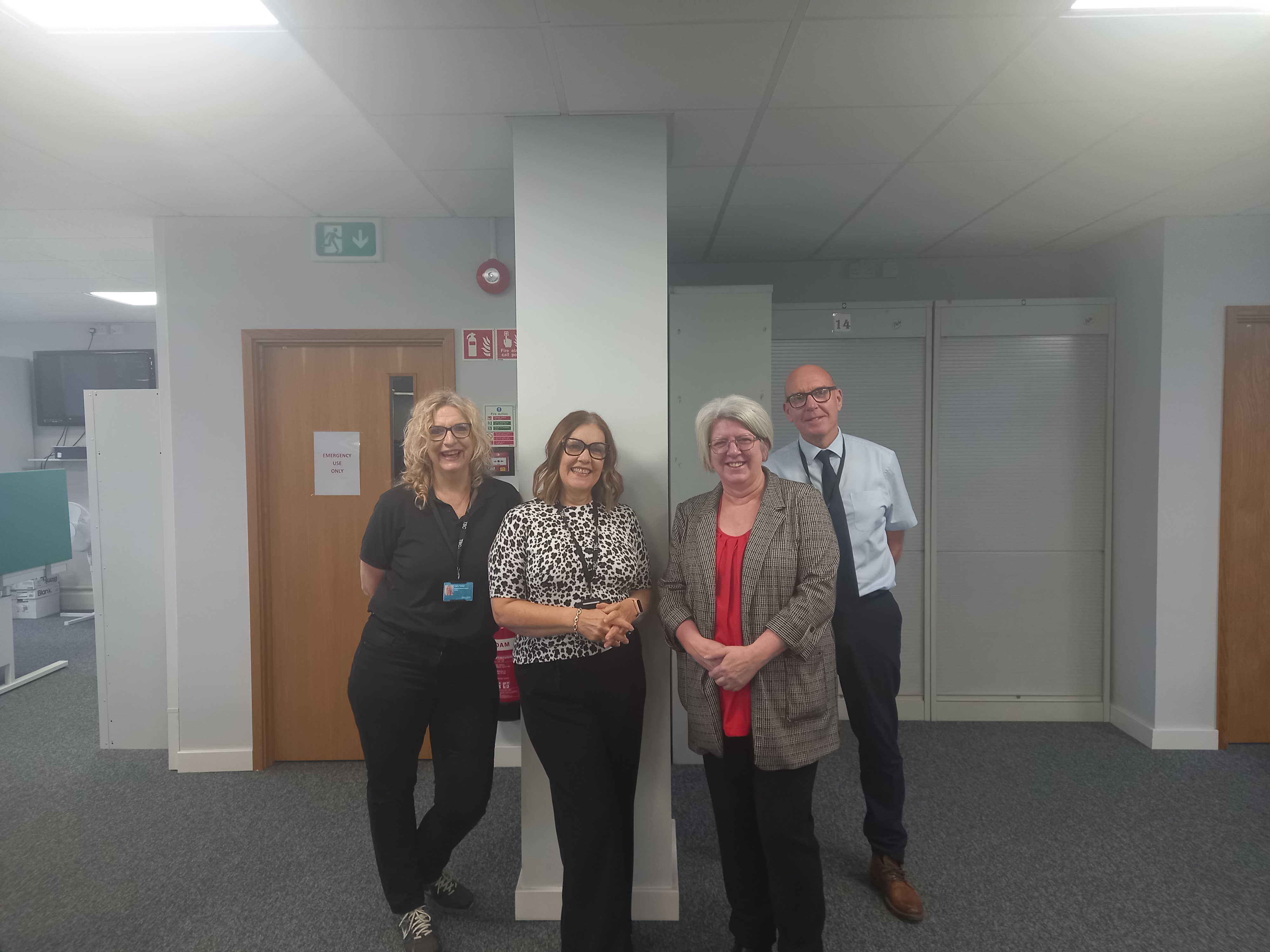 image if 4 people standing in an office