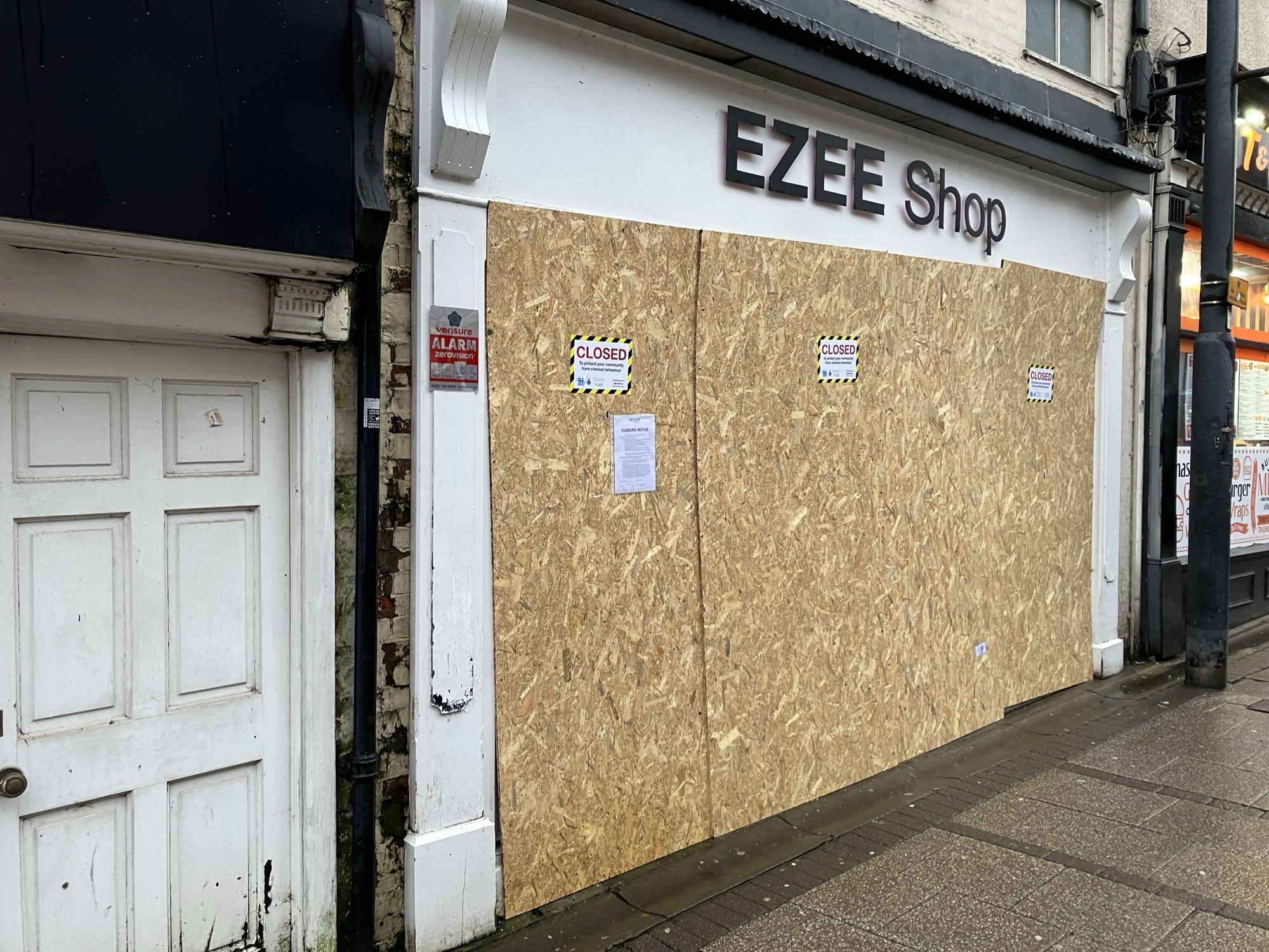 Shop boarded with closure notices on