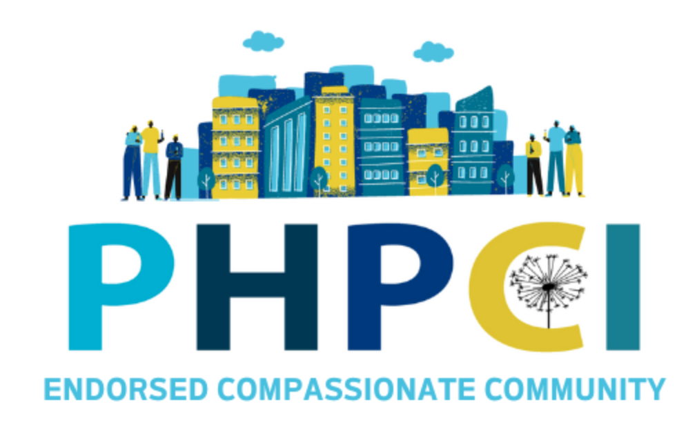 logo for compassionate community statue shows blue and green buildings and text