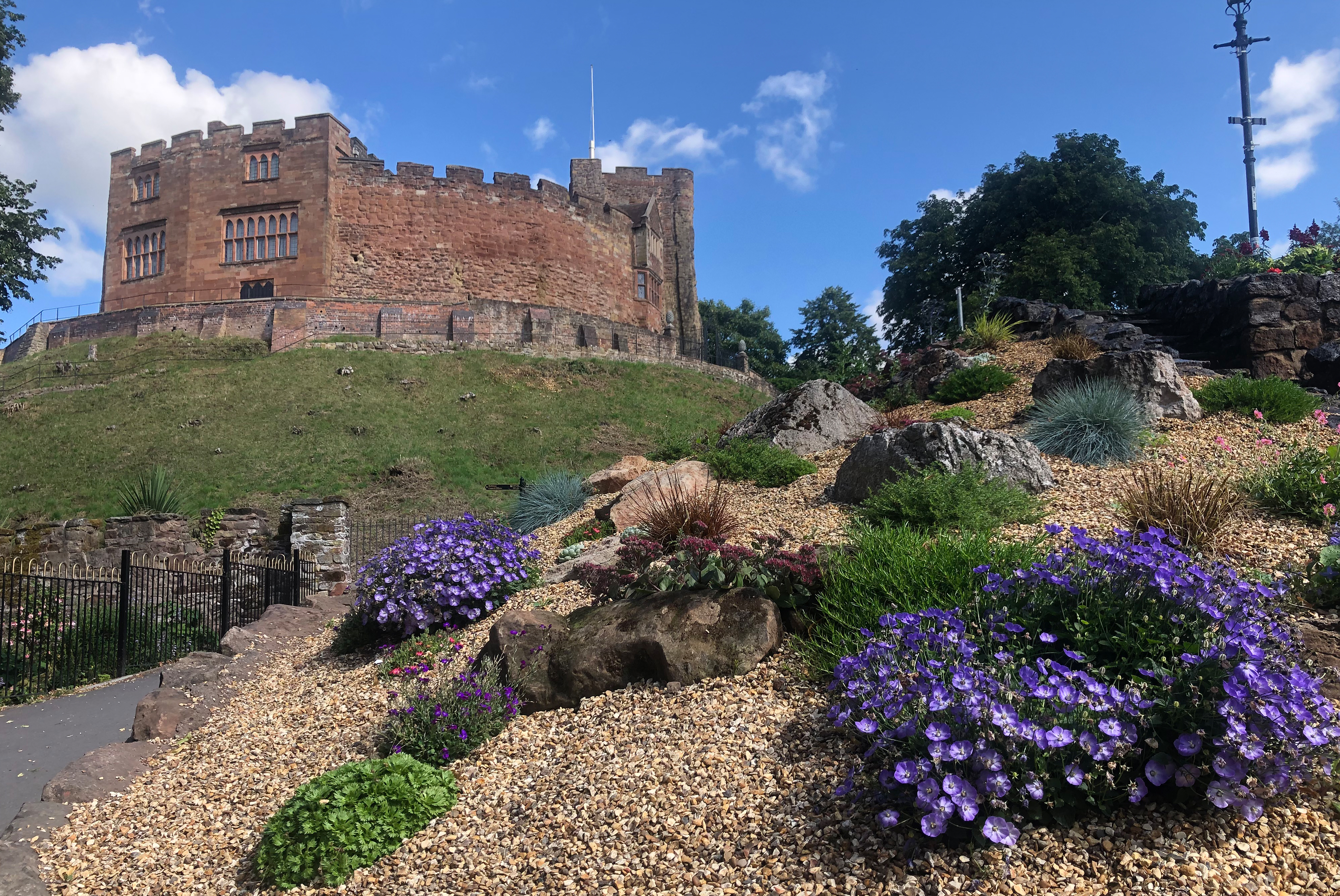 Tamworth Castle behind flower beds with purple and green flowers