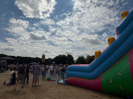 A bouncy castle slide with lots of people stood around it in Tamworth Castle Grounds