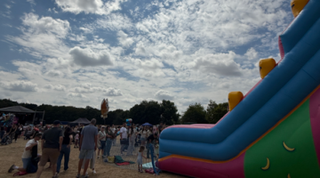 A bouncy castle slide with lots of people stood around it in Tamworth Castle Grounds
